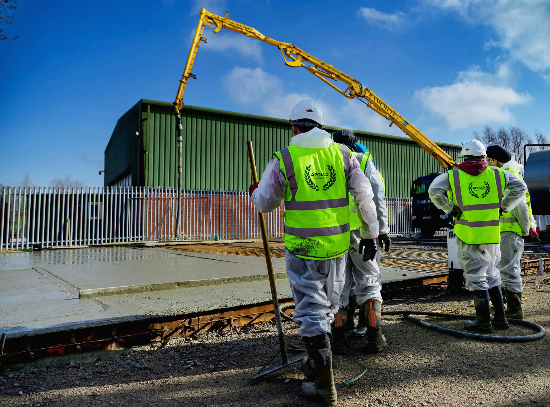 Construction Workers Pouring Fresh Concrete Foundation at Industrial Site
